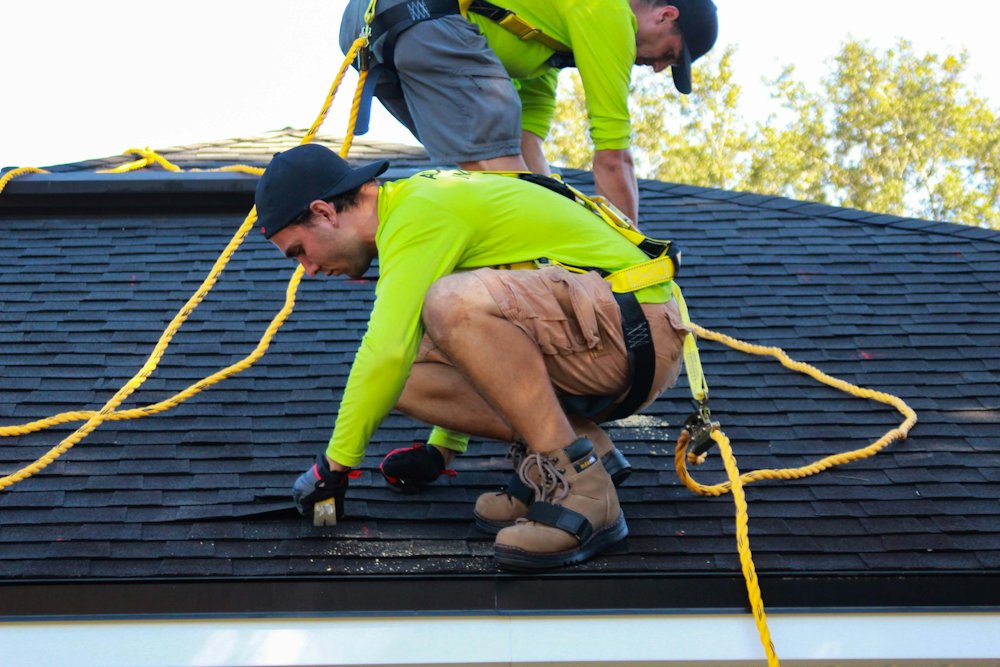 Roofer inspecting shingles up close