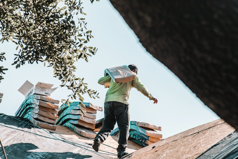 Roofer carrying a bundle of shingles